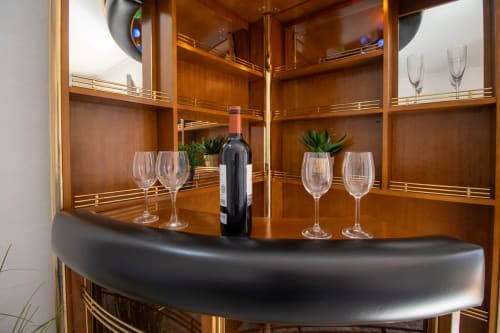 Elegante mueble bar de madera con botella de vino, copas y suculentas en la cabaña La Casa de Tita Clota