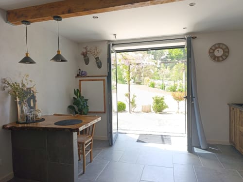 Cuisine-salle à manger moderne de l'appartement La Bergerie de Roger avec vue sur le grand jardin, luminaires suspendus et design contemporain