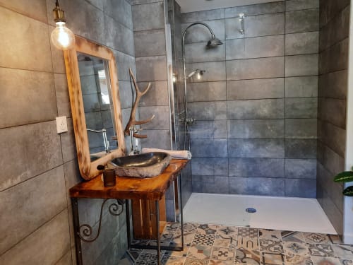 Salle de bain rustique au Petit Bégou avec vasque en pierre, meuble-lavabo en bois, douche à effet pluie et carrelage à motifs