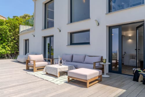 Villa Roya terrace in Saint-Florent with wooden lounge furniture, sea views, and modern white building facade
