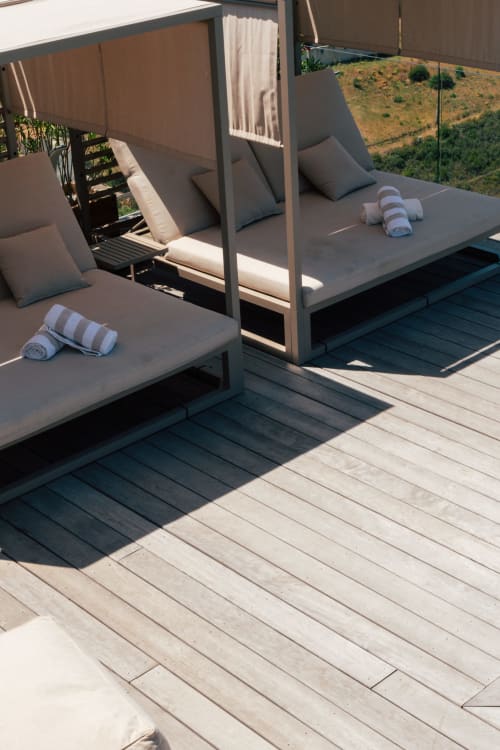 Luxury terrace at Villa Roya with canopy sunbeds, striped towels, and sea views in Saint-Florent, Corsica
