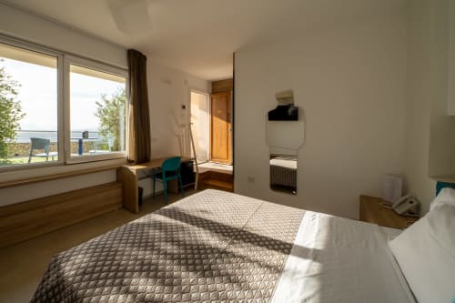 Spacious hotel room at Hotel Belvedere Resort with sea view, double bed, workspace, and modern amenities in Castellammare del