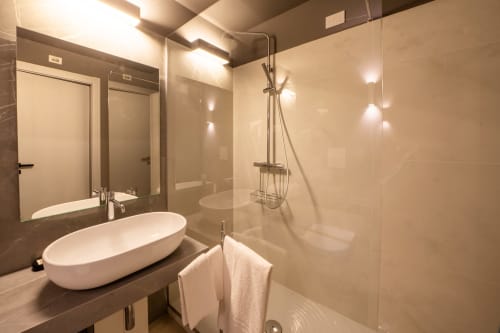 Modern bathroom with oval sink, glass shower, and heated towel rail at Hotel Belvedere Resort, Castellammare del Golfo