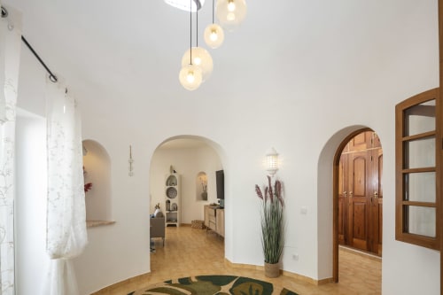 Modern villa entrance in Carvoeiro with arched doorways, pendant lights, and decorative plants