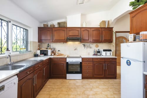 Spacious kitchen in Villa Colina, Carvoeiro with wooden cabinets, white countertops, and modern appliances