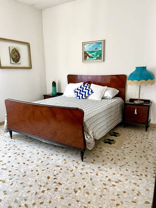 Vintage bedroom in Casa Nicola, WelcHome apartment in San Vito Chietino with wooden bed, striped bedding, and turquoise lamp