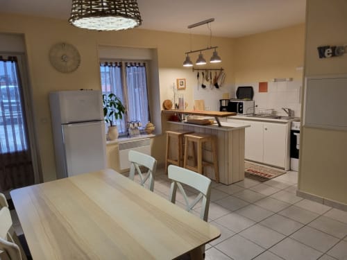 Spacieuse cuisine et salle à manger du Clos De La Côte D'émeraude, Saint-Benoît-des-Ondes avec murs jaunes et îlot