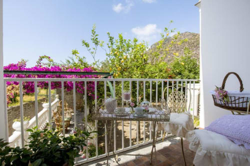 Balcone della Triple Room Bougainvillea con vista sui fiori magenta brillanti e sul giardino in collina del Relais Palazzo Cacace, Meta di