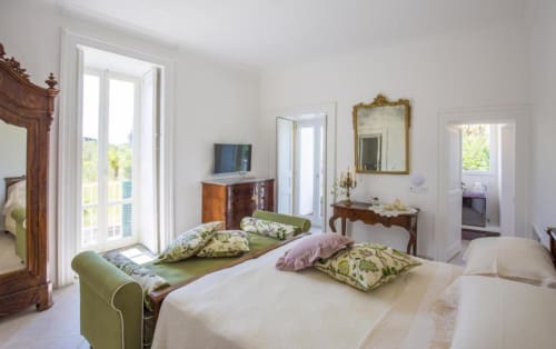 Camera elegante al Relais Palazzo Cacace con vista sul giardino, arredi d'epoca e comfort moderni a Meta di Sorrento
