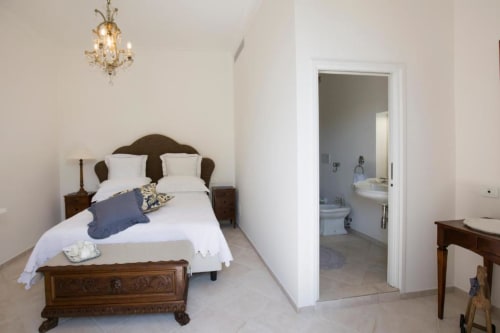 Camera Deluxe Doppia Anthea presso Relais Palazzo Cacace a Meta di Sorrento, con letto in legno, biancheria bianca e bagno privato