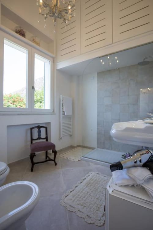 Bagno moderno nella Stanza Tripla Bouganvillea del Relais Palazzo Cacace a Meta di Sorrento, con pavimenti in marmo e cabina doccia