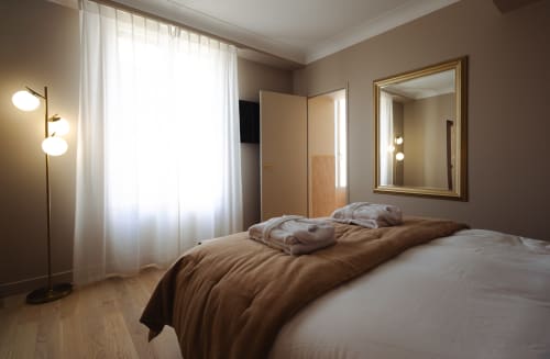 Chambre Joséphine à L'Ode à Pierre à Dax avec lit, miroir, lampe et vue sur le jardin