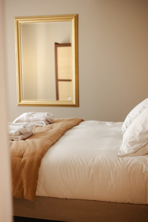 Lit Chambre Joséphine avec oreillers blancs et jeté beige à L'Ode à Pierre B&B, Dax