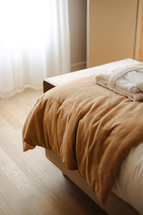 Lit Chambre Joséphine avec literie beige et oreillers blancs à L'Ode à Pierre, Dax