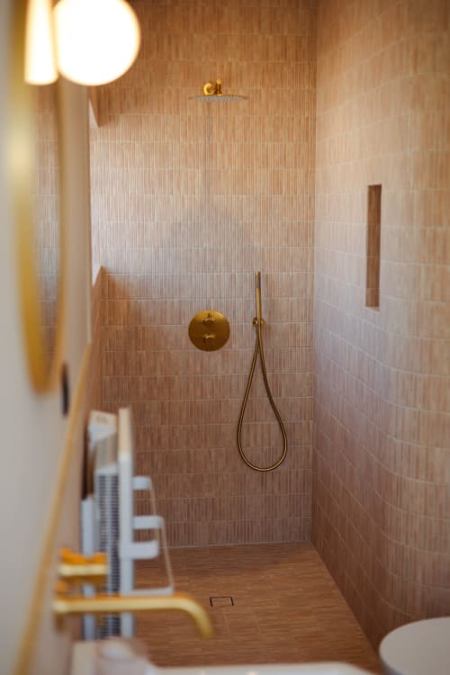 Douche moderne à la L'Ode à Pierre B&B à Dax avec mitigeur en laiton, carrelage texturé en terre cuite et pomme de douche pluie