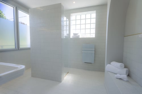Salle de bain moderne à la Chambre Coco de L'Ode à Pierre, Dax. Douche à l'italienne spacieuse, serviettes blanches, lumière naturelle par la fenêtre.