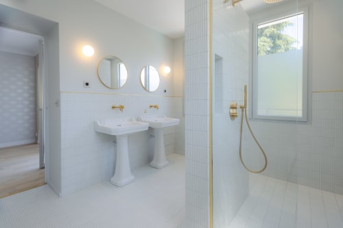 Salle de bains moderne à L'Ode à Pierre à Dax avec deux vasques sur piédestal, robinetterie dorée et douche à l'italienne