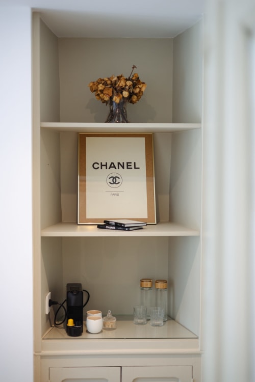 Étagère blanche dans la Chambre Coco à L'Ode à Pierre, Dax, présentant fleurs séchées, art Chanel et objets de décoration