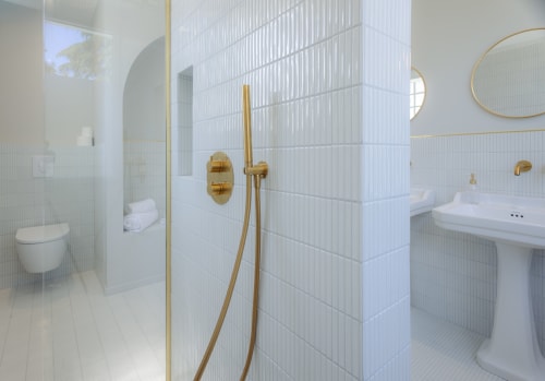 Salle de bain moderne aux carreaux blanc cassé, robinetterie laiton et douche du gîte L'Ode à Pierre à Dax