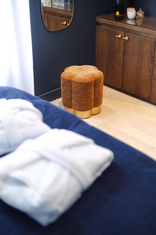 Chambre moderne de L'Ode à Pierre Dax avec ottoman ocre, mobilier en bois et murs bleu marine