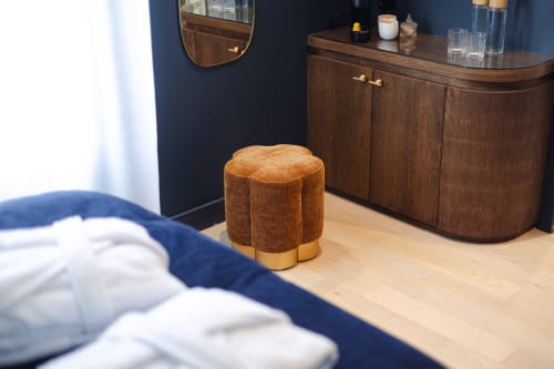 Chambre élégante à L'Ode à Pierre Dax avec ottoman caramel, murs bleu foncé, commode et miroir en bois