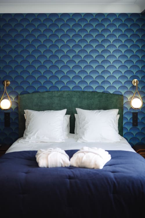 Chambre luxueuse de la chambre d'hôtes L'Ode à Pierre à Dax avec tête de lit verte, papier peint motifs bleus et luminaires suspendus en laiton