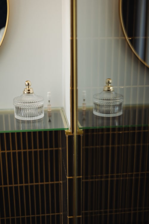 Pots en cristal aux couvercles dorés exposés sur une étagère de la Chambre Mistinguett à L'Ode à Pierre, Dax