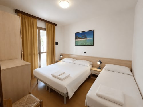 Letti gemelli nell'appartamento con vista mare dell'Anthea Hotel, Lignano Sabbiadoro, con foto della spiaggia e balcone