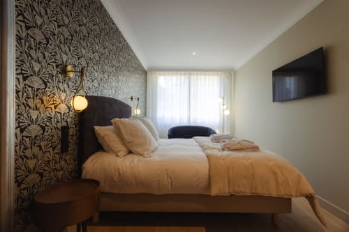 Chambre Gatsby de l'Ode à Pierre B&B à Dax avec papier peint à motifs, tête de lit noire et vue sur le jardin