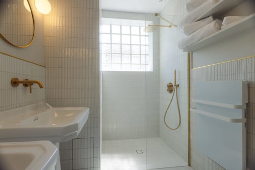 Salle de bain moderne à la Chambre Gatsby de L'Ode à Pierre B&B à Dax avec carrelage blanc, robinetterie laiton, douche italienne et chauffage