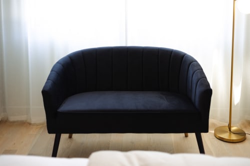 Élégant canapé en velours bleu marine dans la Chambre Gatsby de l'hôtel de charme L'Ode à Pierre, Dax