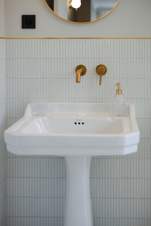 Lavabo blanc moderne sur piédestal avec robinetterie dorée à l'hôtel boutique L'Ode à Pierre à Dax, France