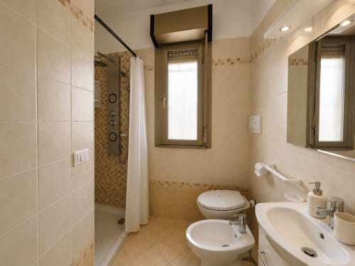 Bagno moderno dell'appartamento Anthea a Lignano Sabbiadoro con doppio lavabo, doccia e bidet