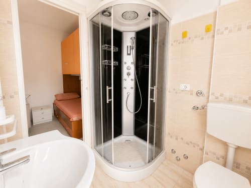 Bagno moderno dell'hotel Anthea a Lignano Sabbiadoro, con cabina doccia con vapore, wc e lavabo