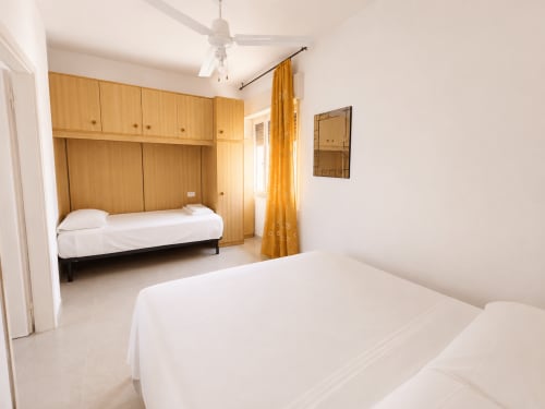 Spacious bedroom at Anthea hotel in Lignano Sabbiadoro with twin beds, wooden wardrobe, and air conditioning