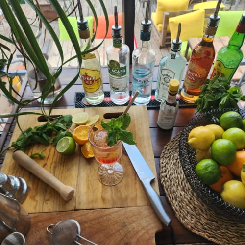 Comptoir de bar à cocktails au BDM Hotel avec alcools, agrumes frais, menthe et plantes tropicales à Montastruc-la-Conseillère