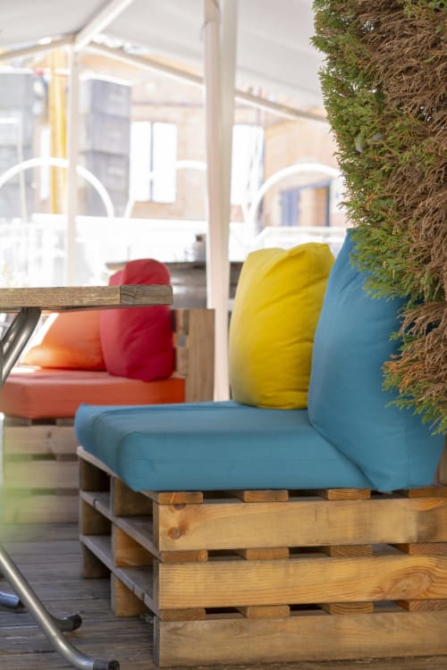 Salon de palettes coloré avec coussins bleu, jaune et rouge à l'hôtel BDM, un gîte à Montastru-la-Conseillère