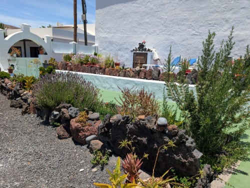Villa encalada en Finca Villanueva Lanzarote con jardín mediterráneo, rocas volcánicas y terraza con vistas al océano en Mala
