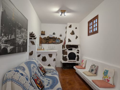 Dormitorio caprichoso de villa en Finca Villanueva Lanzarote con elementos decorativos de piedra, ropa de cama azul estampada y rústico