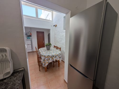 Cocina y comedor de la villa El Recuerdo, Finca Villanueva Lanzarote, con nevera de acero inoxidable y zona de comidas