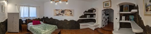 Dormitorio de la villa El Recuerdo en Finca Villanueva con cama, arte decorativo en pared, estantería y mobiliario rústico en Mala
