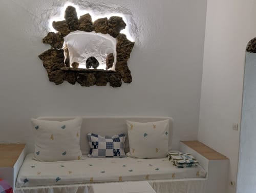 Acogedor rincón de dormitorio en villa Finca Villanueva Lanzarote con asientos blancos, cojines decorativos y arte mural texturizado