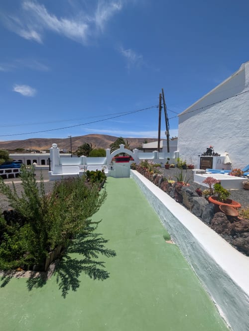 Campo de minigolf en Finca Villanueva Lanzarote con arquitectura blanca y vistas al paisaje volcánico en Mala, Canarias