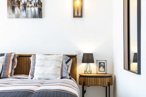 Cozy bedroom at MarVillas Rentals in Lagoa with wooden bed, striped bedding, nightstand lamp, and wall art