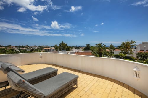 Rooftop terrace at MarVillas Rentals in Lagoa with lounge chairs, ocean views, and coastal landscape