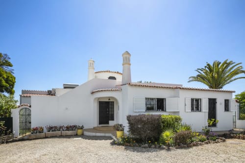 White Algarve villa with minarets in Lagoa, Portugal. MarVillas Rentals property with palm trees and Mediterranean garden.