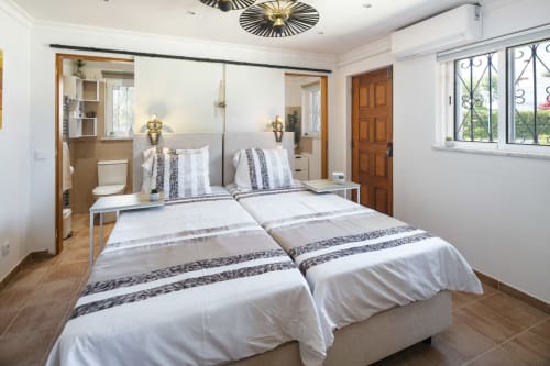 Modern bedroom at MarVillas Rentals in Lagoa with twin beds, en-suite bathroom, and bright windows