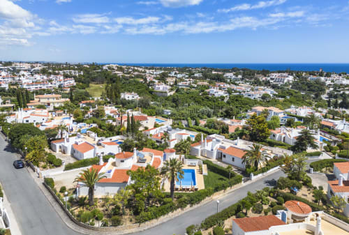 Aerial view of MarVillas Rentals in Lagoa, Portugal with Mediterranean villas, pools, and ocean horizon