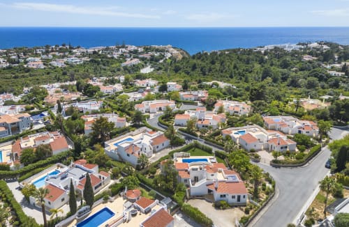 Aerial view of luxury villas with pools in Lagoa, Portugal overlooking the Algarve coastline and Mediterranean sea