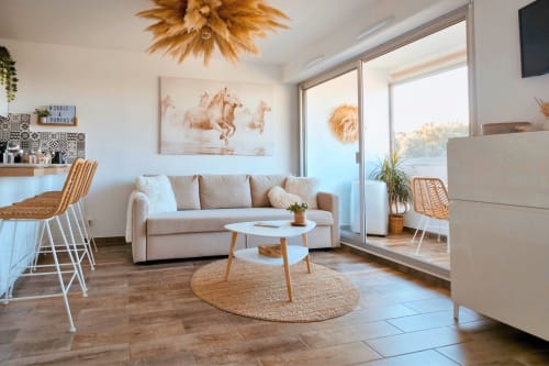 Salon moderne du Sable & Pampas BnB à Carnon-Plage avec canapé beige, touches tissées et vue côtière